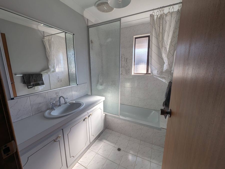 Bathroom cleaned by ZeroGrime Solutions, showing spotless tiles, shower screen, vanity and mirror