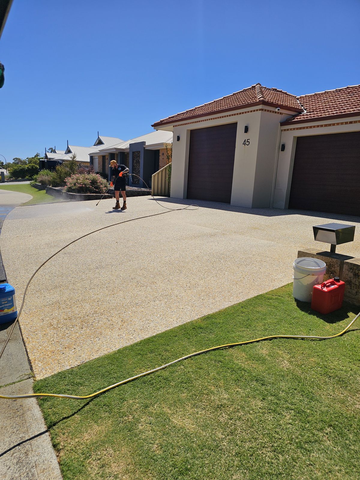 Wide residential concrete driveway being pressure washed by ZeroGrime Solutions near Bunbury, Western Australia